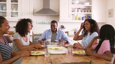 Family With Teenage Children Eating Meal In Kitchen Видео