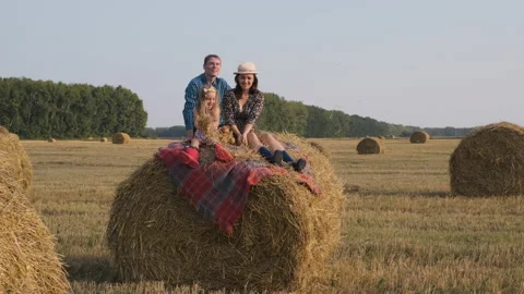 Family of Three Having Fun on a Hay Bale Stock Footage 160056470