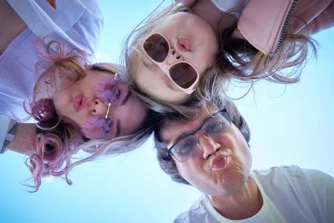 Family of three looking down at the camera. Stock Photos