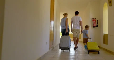 Family of three with roll-on bags in hotel Stock Footage