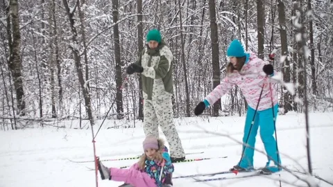 A family of three is skiing between the trees through the forest in winter Stock Footage 73349583