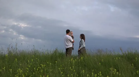 Family together on spring meadow, dramatic sky, beautiful landscape 4K Stock Footage 46206071