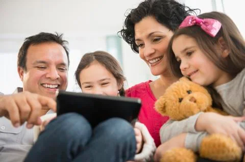 Family using digital tablet together on sofa Stock Photos