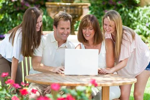 Family using laptop computer outside in garden Stock Photos