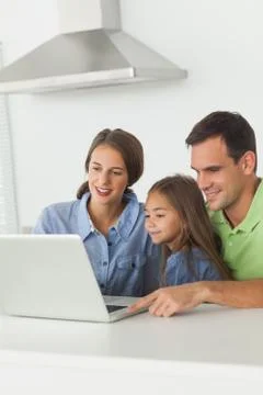 Family using a laptop pc on the kitchen table Foto stock
