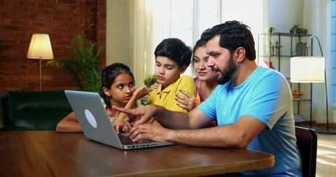 Family using laptop together at dining table while planning vacation Video stock 342487434