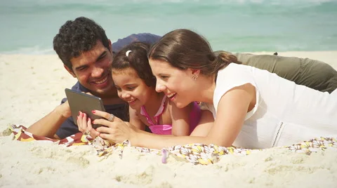 Family using a tablet computer on a beach Video stock 49610178