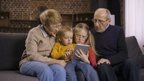 Family using tablet pc on sofa together at home Video stock 85101519