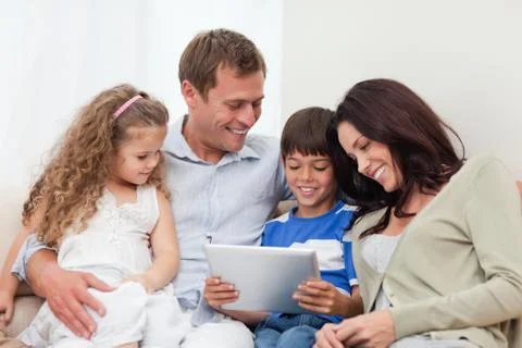 Family using tablet on the sofa Stock Photos