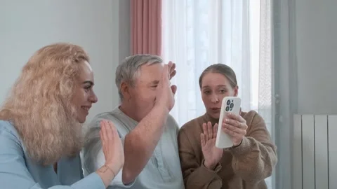 Family video call using smartphone. Elderly father with two adult daughters Stock Footage 315861227