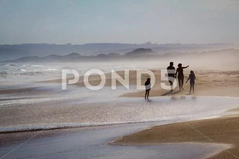 Family walking along foggy beach Stock Photos