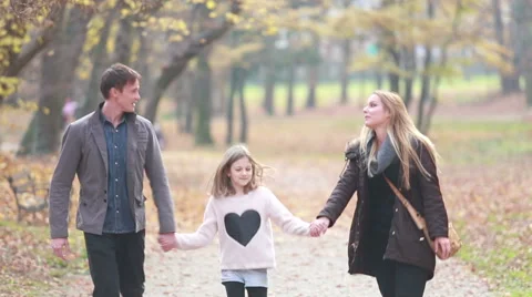 Family walking in the park, father takes daughter in his arms Stock Footage 59554233
