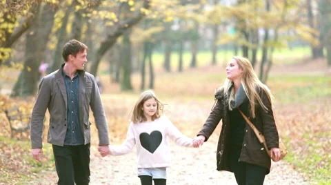 Family walking in the park, father takes daughter in his arms Stock Footage 59554237