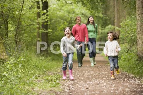 Family walking on path holding hands smiling Stock Photos