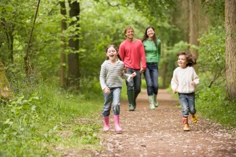 Family walking on path holding hands smiling Stock Photos