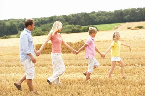 Family Walking Together Through Summer Harvested Field Stock Photos