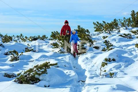 Family walking on winter mountain slope Stock Photos