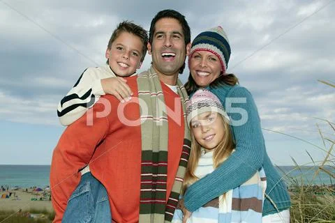 Family In Warm Clothes At The Coast
