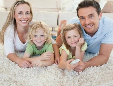 Family watching tv on the floor Stock Photos