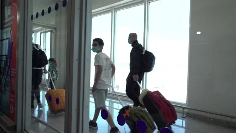 A family wearing masks arrives with their suitcases at the airport during th Stock Footage