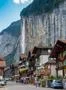 Famous alps waterfall at Lauterbrunnen village center and steep wall mountain Photo