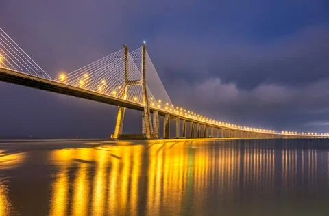 The famous cable-stayed Vasco da Gama bridge in Lisbon at night Stock Photos