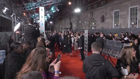 Famous celebrities walking on red carpet while being photographed, BAFTA - 2020 Stock Footage