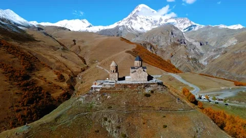 Famous Gergeti Trinity Tsminda Sameba Church In Autumn in Mount Kazbegi Stock Footage 224906403