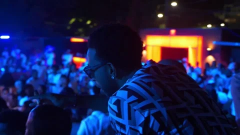Famous rapper Ludacris dances as sparkling bottles are served below him in Video stock 134372272