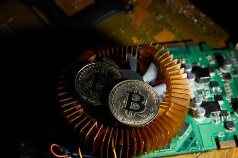 A fan with a bitcoin on it sits on a computer chip..cryptocurrency, bitcoin.. Stock Photos