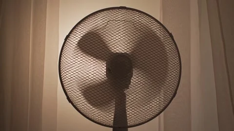 Fan blades spinning in front of window with soft backlight Stock Footage 313147292