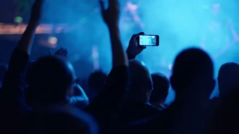 Fan clapping and another filming concert in teal blue light Stock Footage 334351952