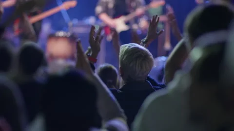 Fan clapping hands at live concert with blurred stage behind Stock Footage 334287966