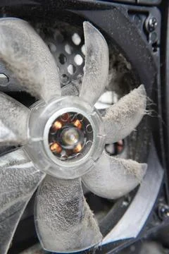 The fan is dusty inside the computer. A dirty cooling element of the system. Stock Photos