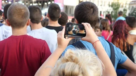 Fan female spectator in concert people crowd try shoot video via smart phone Stock Footage