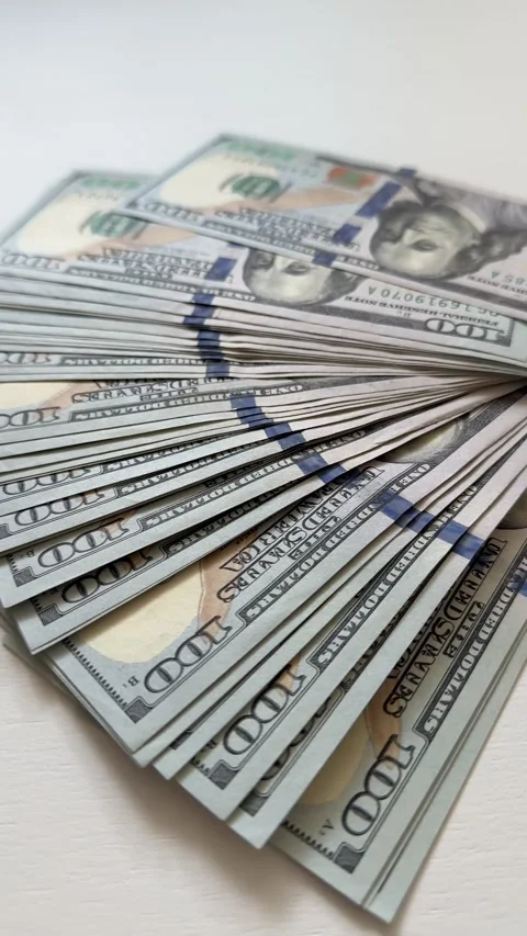 Fan of one hundred dollar bills arranged in wide semicircle on white Stock Footage 345175048