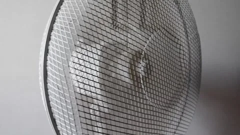 The Fan is Spinning on a White Background. A Stylish Modern White Fan Blows  Stock Footage 246544943