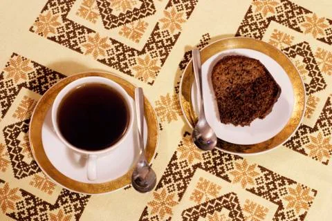 Fancy bread and tea cup on embroidered table cloth 스톡 사진