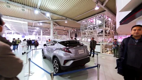Fancy gray car and visitors looking at it in Toyota Mega Web. Tokyo, Japan Stock Footage