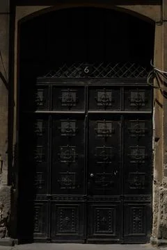 Fancy old entry front door with small designed iron barred windows Stock Photos