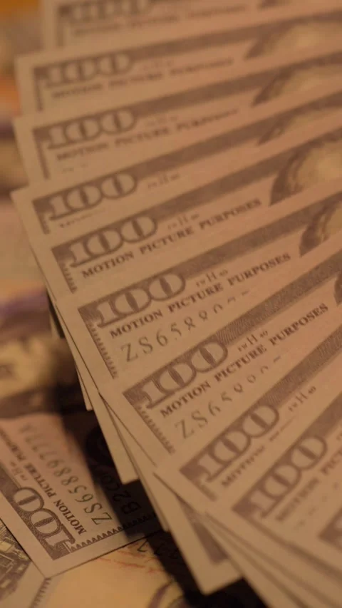 Fanned dollar bills pulled through warm light Stock Footage 345089430