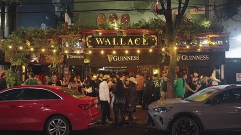 Fans crowd outside the Wallace bar at night Stock Footage 345278506
