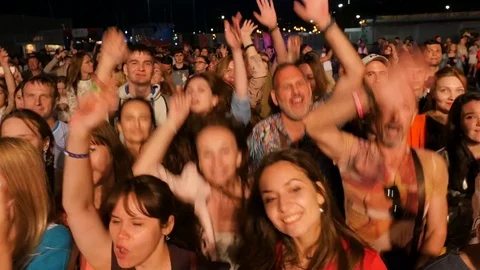 Fans Dance by Jumping behind Fence at Band Concert Stock-Footage 82556576