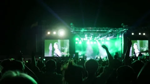 Fans jump and dance at concert, excited audience waving hands at rock festival Stock Footage