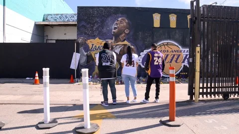 Fans with Kobe Bryant jerseys standing at memorial mural - Steadi cam movement Видео 124114218