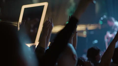 Fans raising hands and clapping at live concert with stage bokeh Stock Footage 334288778