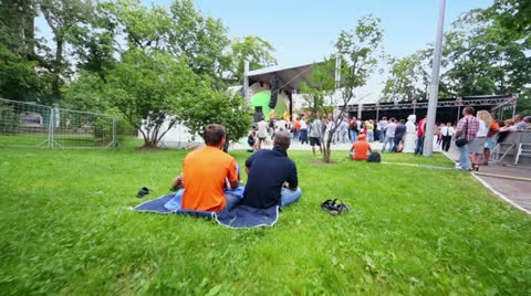 Fans sit on grass and stand near stage at concert of Chaif band Vidéo 26084443