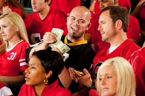 Fans: visiting team fan counts money from bet Stock Photos