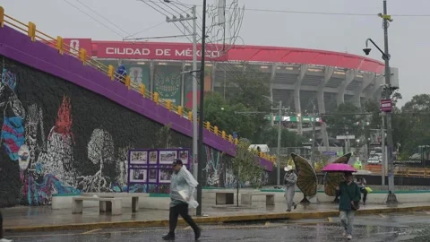 Fans walk toward Estadio Azteca in the rain Stock Footage 345278470