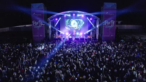 Fans watch singer performance near entertainment center Stock Footage 127753889